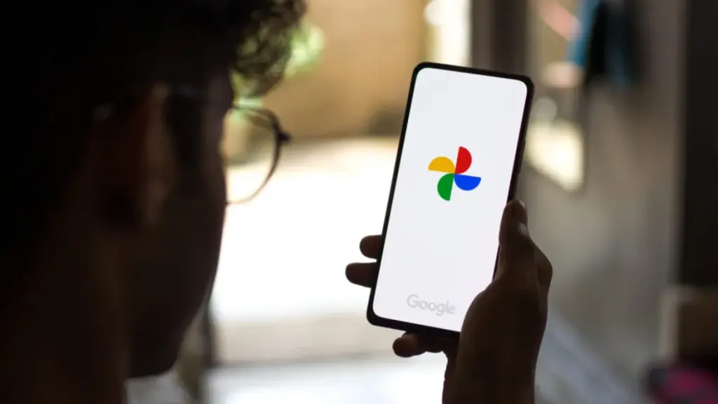 Homem usando Google Fotos em seu smartphone para visualizar imagens