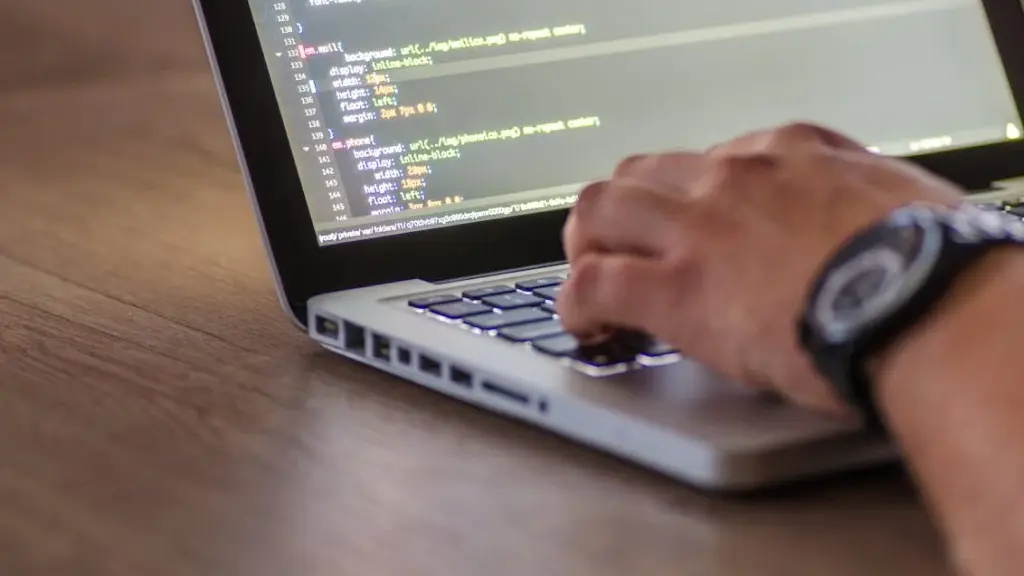 Mão masculina digitando códigos em um notebook, representando SEO para softwares B2B